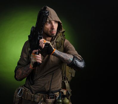 the man Stalker with a gun with an optical sight and a backpack on a dark background with emotions looking, aiming, watching, sneaking