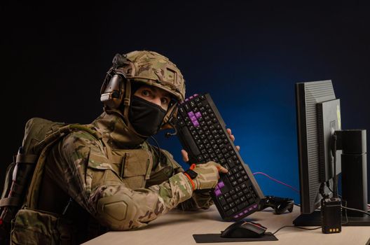 soldier sitting at a computer is conducting a cyber war