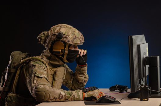 soldier sitting at a computer is conducting a cyber war