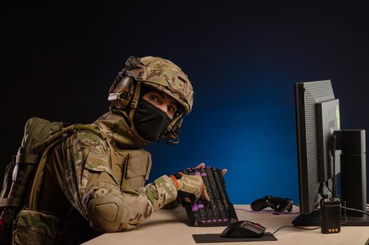 soldier sitting at a computer is conducting a cyber war