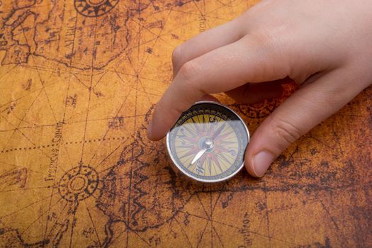 Hand is holding a magnetic compass on black background