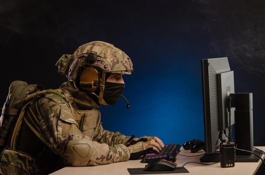 soldier sitting at a computer is conducting a cyber war