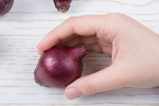 Whole red onion bulbs in brown on wooden background