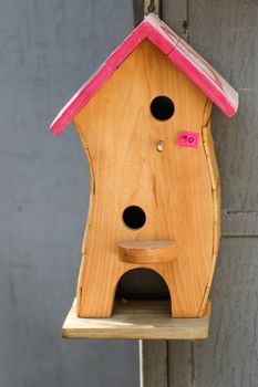 Wooden bird house with little round holes