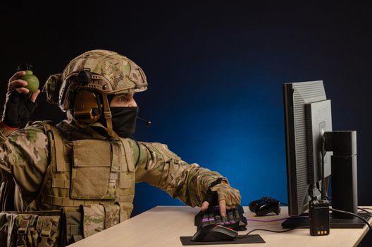 soldier sitting at a computer is conducting a cyber war