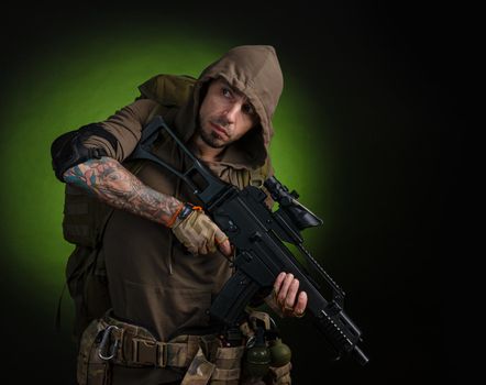 the man Stalker with a gun with an optical sight and a backpack on a dark background with emotions looking, aiming, watching, sneaking