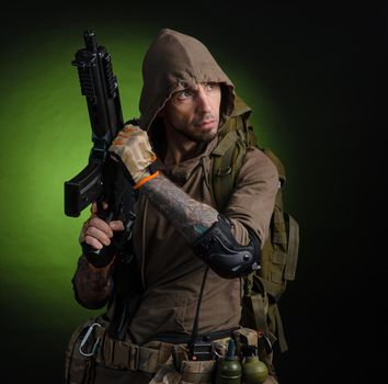 the man Stalker with a gun with an optical sight and a backpack on a dark background with emotions looking, aiming, watching, sneaking