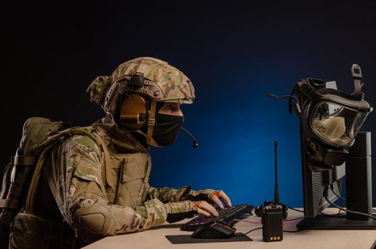 soldier sitting at a computer is conducting a cyber war