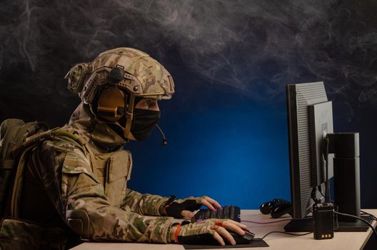 soldier sitting at a computer is conducting a cyber war