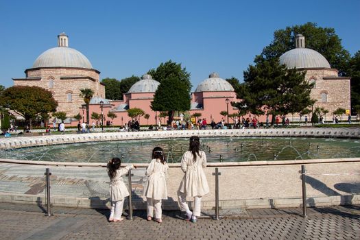 Three little girls by the pool with domes in Istanbul