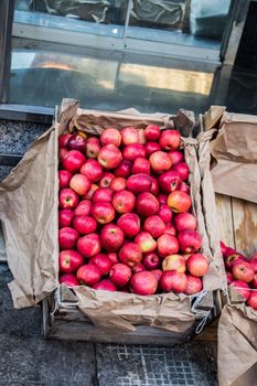 Fresh organic red apples are in wooden crate at bazaar