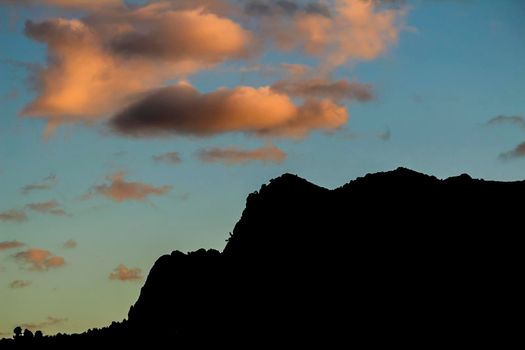 Spectacular sunset with colorful clouds and silhouette of mountains in Guadalest, Alicante, Spain