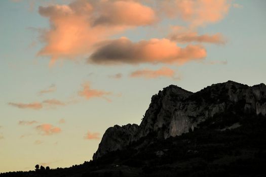 Spectacular sunset with colorful clouds and silhouette of mountains in Guadalest, Alicante, Spain