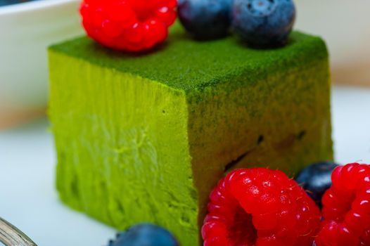 green tea matcha mousse cake with raspberries and blueberries on top