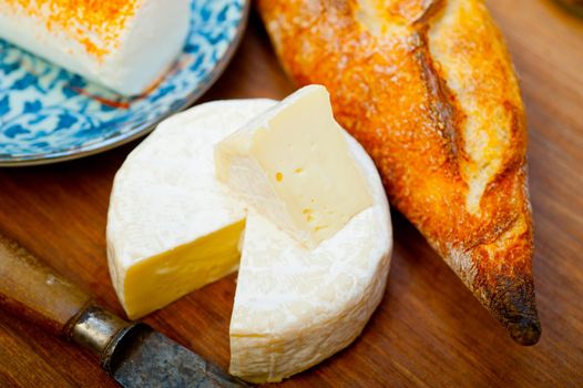 French cheese and fresh  baguette on a wood cutter