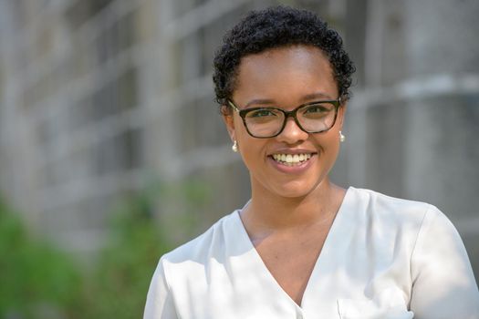 A young pretty African American businesswoman in a park with summer temperatures.