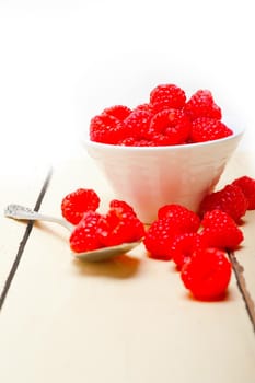 bunch of fresh raspberry on a bowl and white wood rustic  table