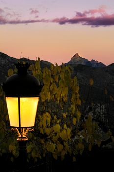 Sunset in Guadalest village with beautiful view of the valley. Vintage lamppost in the foreground.