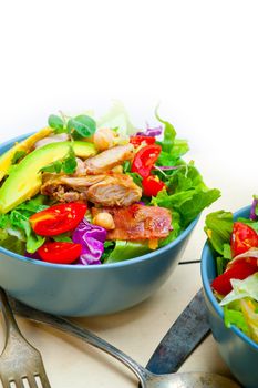 fresh and healthy Chicken Avocado salad over rustic wood table