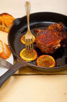 pork chop seared on iron skillet with lemon and spices seasoning