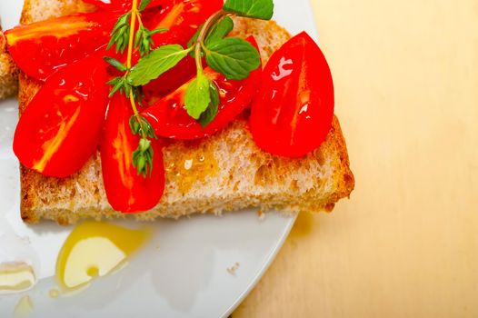 Italian tomato bruschetta with thyme and mint leaves 