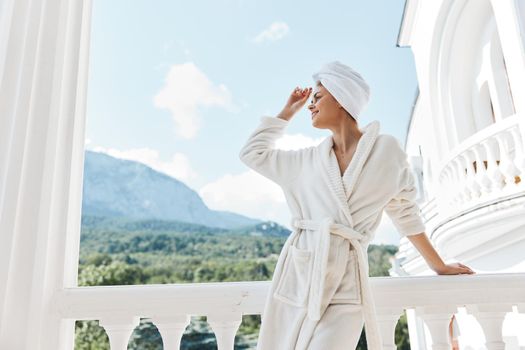 Attractive young woman posing against the backdrop of mountains on the balcony architecture Lifestyle. High quality photo