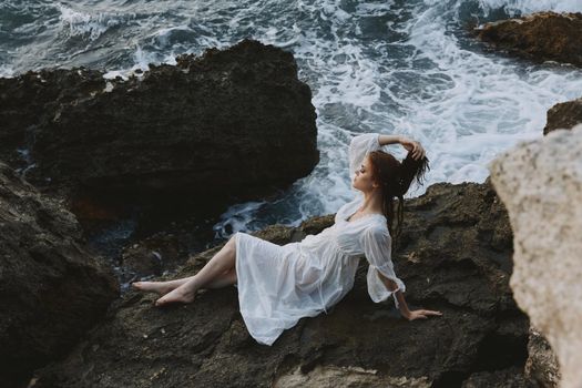 woman Lies on his back on a stone cliff, cloudy weather view from above. High quality photo