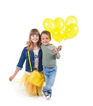 teen girl and boy with yellow balloons on white background