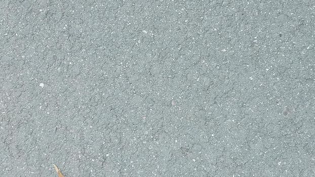 Close-up of an asphalt highway. Grunge background with grey asphalt texture. The texture of an asphalt road, sidewalk, tile. 