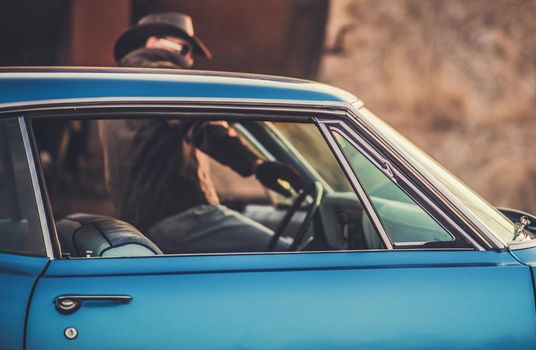 Oldtimer Classic Ride. Caucasian Cowboy Getting Into the Car. Closeup Photo. Transportation and Lifestyle Theme.