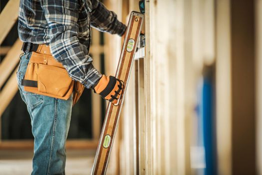 Contractor Worker Taking Spirit Level Tool to Make Sure the Wooden Frame Alignment is Correct. Construction Tools and Building Technologies.