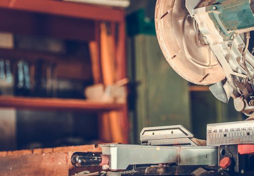 Close Up View Of Electric Chop Saw With Circular Blade Designated To Cut Wooden Material Inside Of Workshop. 