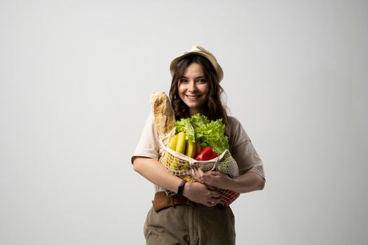 Woman holding cotton grocery bag with vegetables, greens. Reusable eco bag for shopping. Zero waste concept. Sustainable lifestyle. Eco friendly concept