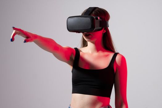 Happy young woman playing on VR glasses. Virtual reality concept with young girl having fun in virtual reality goggles. Metaverse