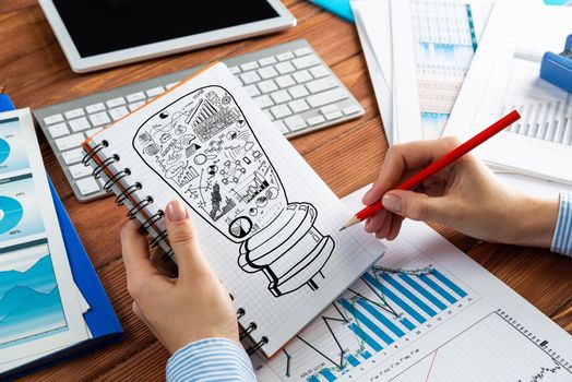 close-up, woman draws business notes in her notebook. Business Innovation Concept