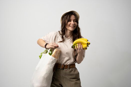 Zero waste concept. Young woman holding reusable cotton shopping bag with groceries from a market. Concept of no plastic. Zero waste, plastic free. Eco friendly concept. Sustainable lifestyle