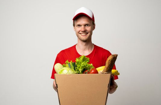 Courier carrying package box of grocery food and drink from store