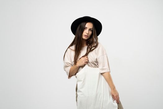 Brunette woman in a beige t-shirt and black hat with a cotton shopper bag with groceries. Reusable eco bag for shopping. Zero waste concept