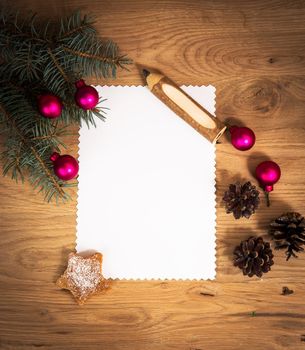 blank sheet of paper on the wooden floor with a pencil and Christmas decorations