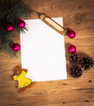 blank sheet of paper on the wooden floor with a pencil and Christmas decorations