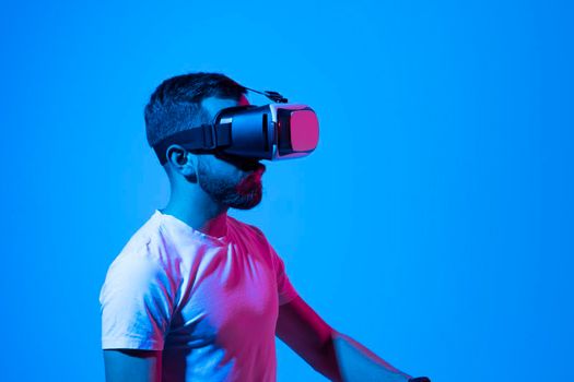 Bearded young man wearing virtual reality goggles and interacting with a virtual environment. Future technology concept. Metaverse