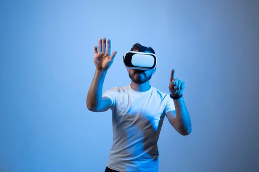 Modern architect, designer using virtual reality glasses at workplace. Designer working in augmented reality vr studio. Man working in VR goggles on a studio background