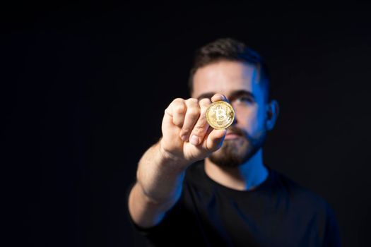 Golden Bitcoin in a young businessman hand. Digitall symbol of a new virtual currency. Cryptocurency