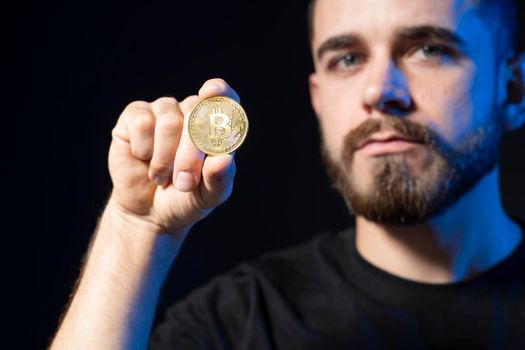 Golden Bitcoin in a young businessman hand. Digitall symbol of a new virtual currency. Cryptocurency