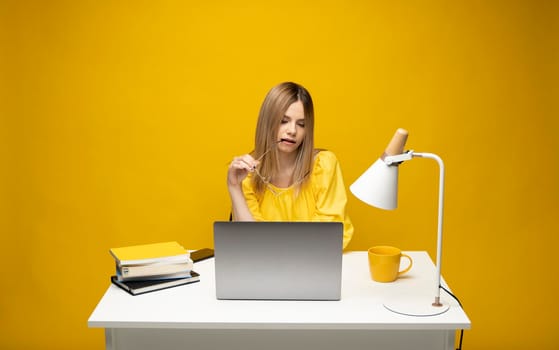 Studio portrait of young successful secretary employee business woman wear yellow t-t-shirt sit work at white office desk with laptop browsing internet online