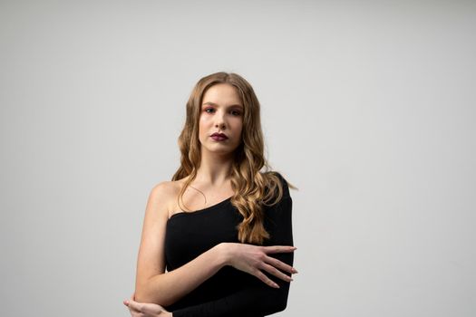 Beautiful young woman portrait in a black t-shirt. Studio shot, isolated on gray background