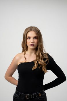 Beautiful young woman portrait in a black t-shirt. Studio shot, isolated on gray background