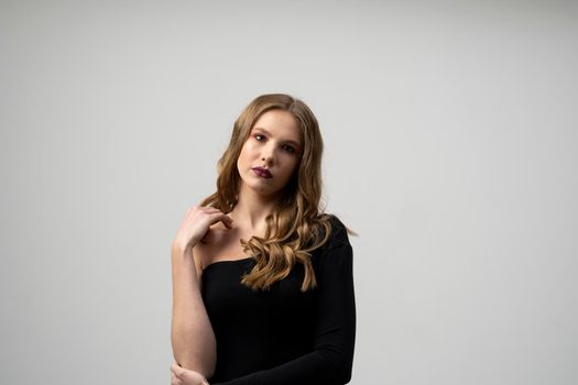 Beautiful young woman portrait in a black t-shirt. Studio shot, isolated on gray background