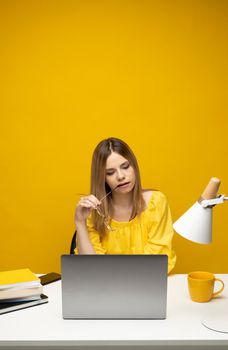 Studio portrait of young successful secretary employee business woman wear yellow t-t-shirt sit work at white office desk with laptop browsing internet online