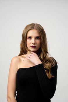 Beautiful young woman portrait in a black t-shirt. Studio shot, isolated on gray background